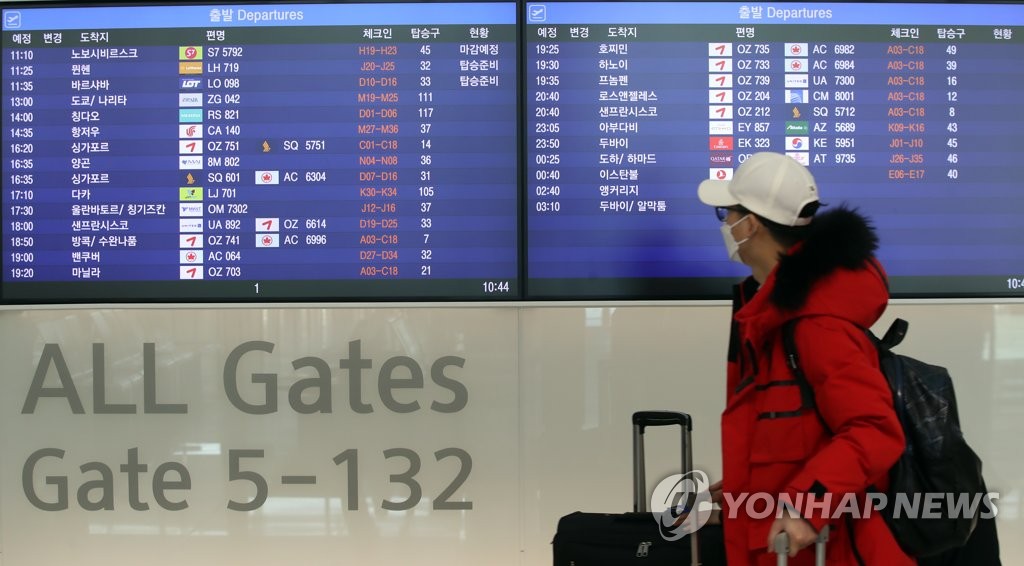1月4日，在永宗岛仁川国际机场第一航站楼，旅客走过航班时刻表。 韩联社