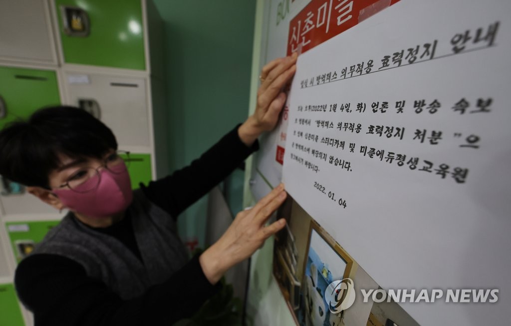1月4日，在首尔新村一自习咖啡厅，工作人员张贴“停止适用防疫通行证”通知。 韩联社 