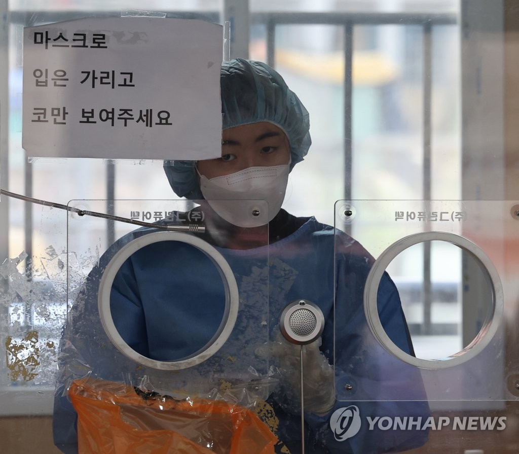 资料图片：1月5日，在设于首尔站的新冠临时筛查诊所，医务人员为新冠核酸检测做准备。 韩联社