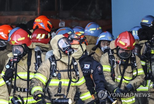 1月6日，在京畿道平泽市，消防员走出一处新楼建筑工地火灾现场。 韩联社
