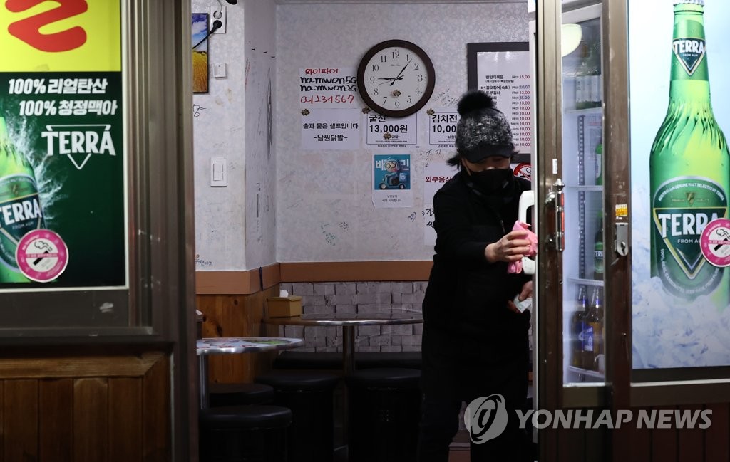 资料图片：个体工商户在晚9点后开灯抗议政府疫情防控政策。 韩联社