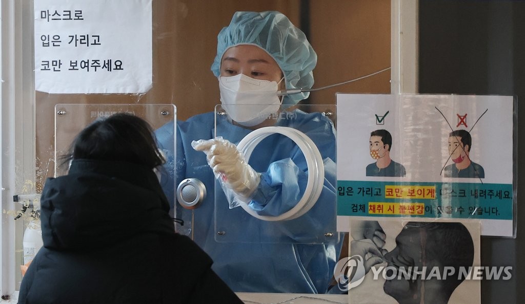 1月13日上午，在首尔站广场，医务人员进行核酸检测采样。 韩联社