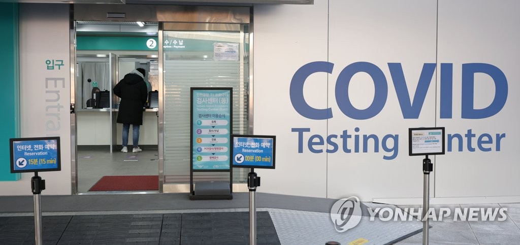 1月13日，在仁川国际机场第一航站楼，旅客等待核酸采样。 韩联社