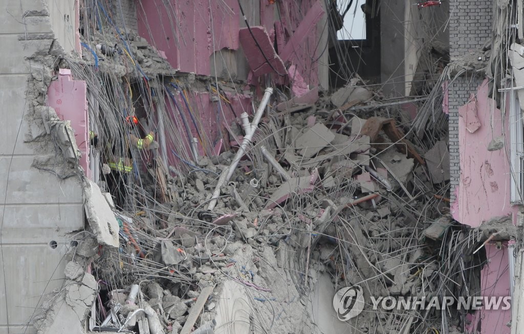1月13日，在光州西区花亭洞，搜救队员正在发生坍塌事故的在建公寓施工现场搜寻失踪人员。 韩联社