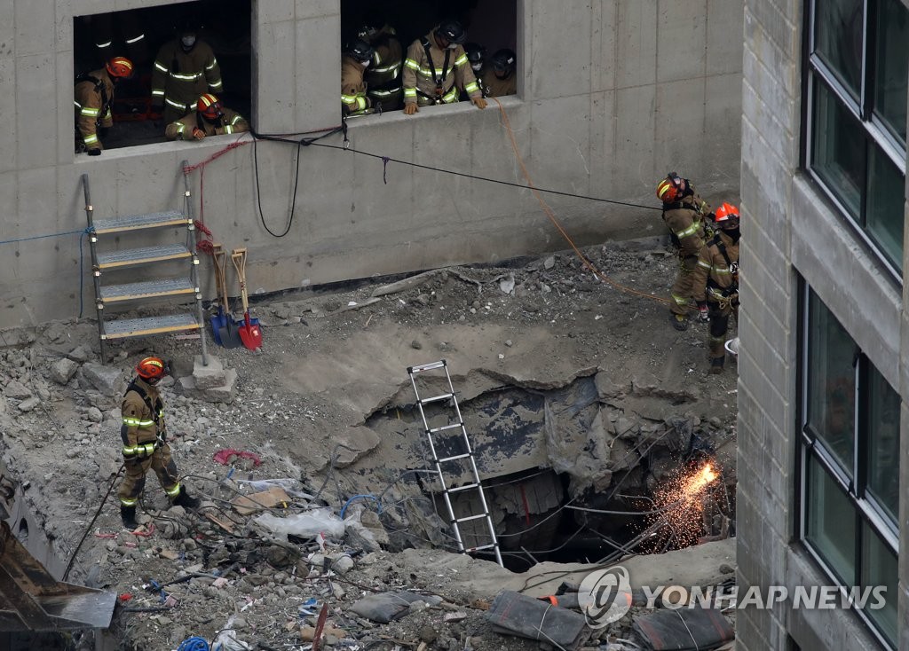 资料图片：1月16日，在光州在建公寓坍塌事故现场，消防队员正在继续展开搜救活动。 韩联社