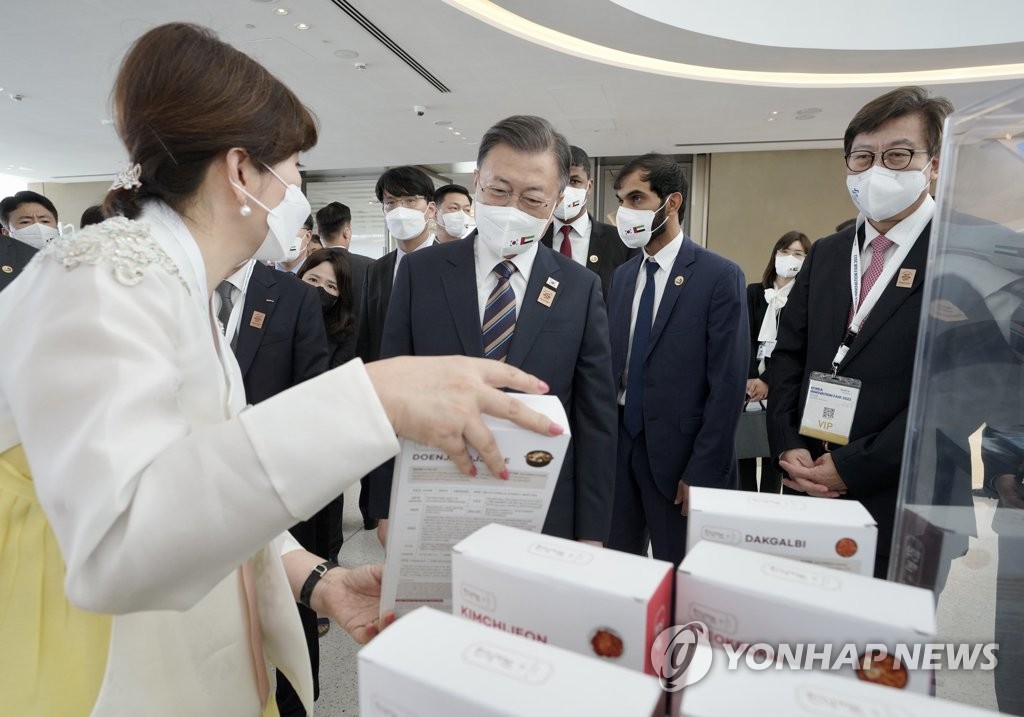 当地时间1月17日，韩国名优产品展在阿联酋迪拜世界博览会展馆举行。图为韩国总统文在寅（前排左二）参观韩餐振兴院展区。 韩联社
