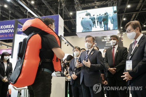 当地时间1月17日，韩国名优产品展在阿联酋迪拜世界博览会展馆举行。图为韩国总统文在寅（右三）听取安全设备。 韩联社