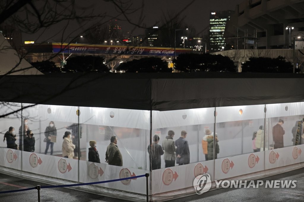 资料图片：1月25日，在设于首尔松坡区蚕室综合运动场第2停车场的临时筛查站，市民们排队候检。 韩联社