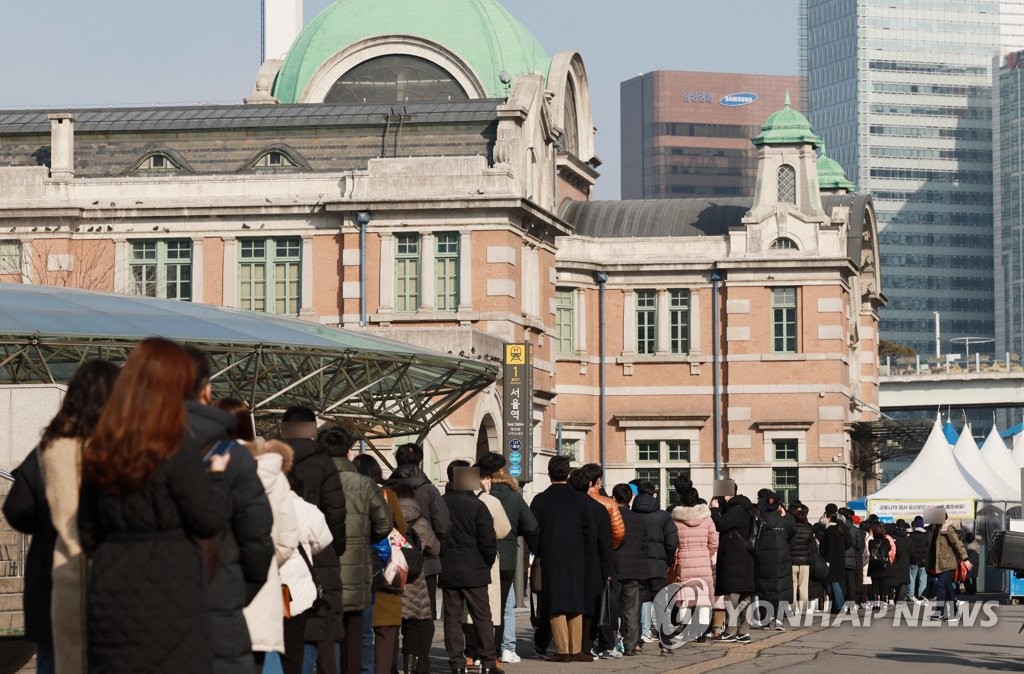 资料图片：1月27日，在首尔火车站广场的临时筛查诊所，市民排长队等待接受病毒核酸检测。 韩联社