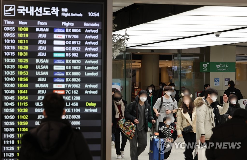 2月2日，在金浦机场国内航线航站楼，乘客走出到达大厅。 韩联社