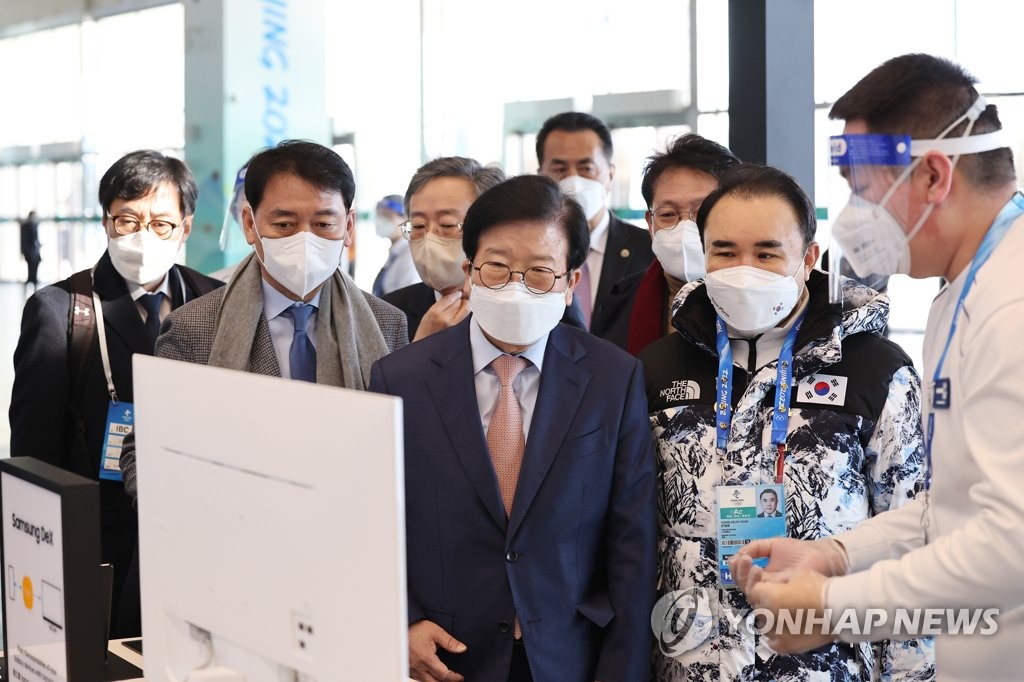 2月4日，在北京冬奥会主媒体中心（MMC），韩国国会议长朴炳锡（右三）一行参观主媒体中心内的三星电子展位。 韩联社