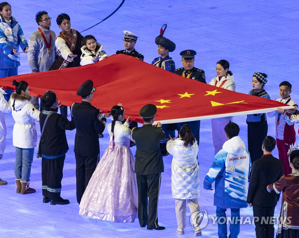 资料图片：2月4日，2022北京冬奥会开幕式在中国北京的国家体育场举行，一名身穿韩服的表演者出现在国旗传递环节。 韩联社