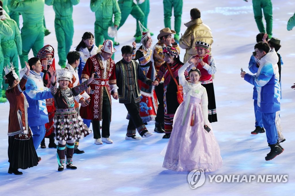 资料图片：2月4日，2022北京冬奥会开幕式在中国北京的国家体育场举行，一名身穿韩服的表演者挥手致意。 韩联社