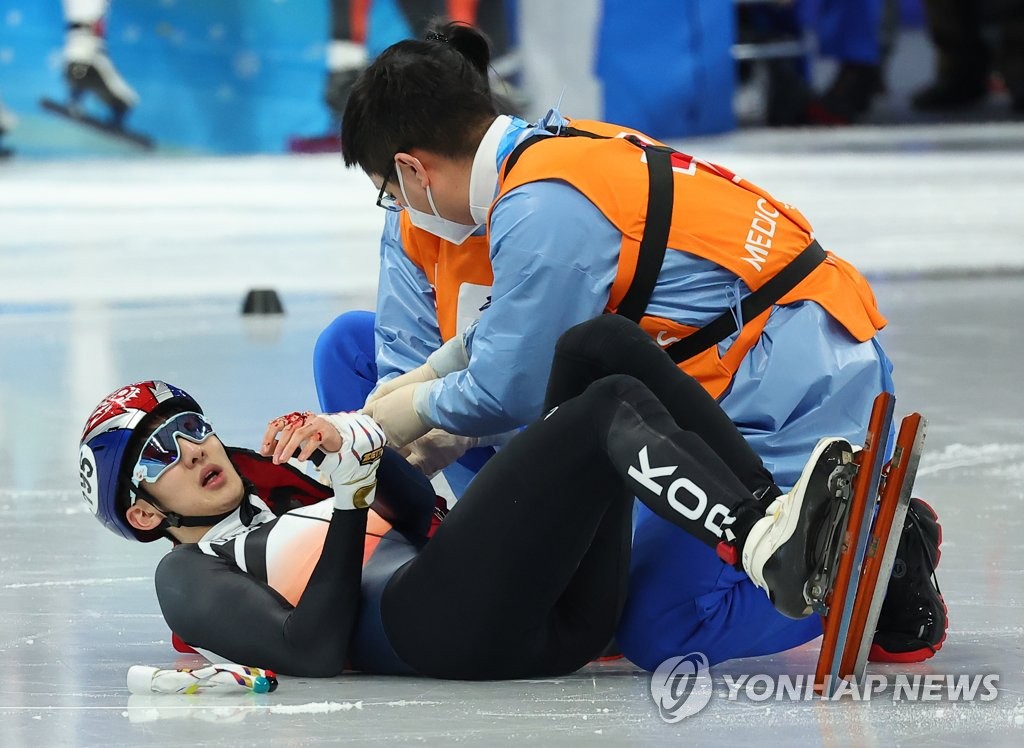 2月7日，在北京冬奥会短道速滑男子1000米1/4决赛小组赛上，韩国短道速滑选手朴章爀（左）左手受伤。 韩联社/短道速滑代表队供图（图片严禁转载复制）