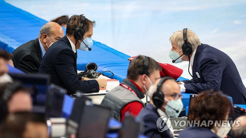 2月7日，北京冬奥会短道速滑男子1000米半决赛在北京首都体育馆举行。图为主裁判彼得·沃思（右）与录像裁判交谈。 韩联社