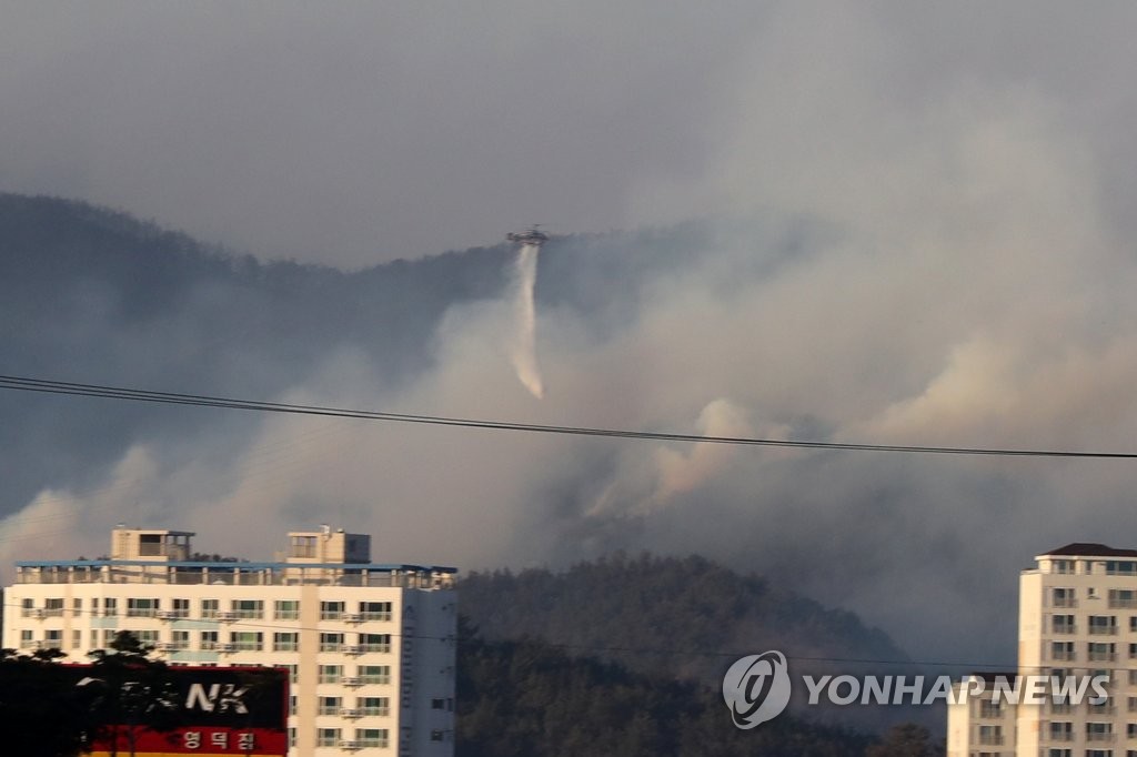 2月16日，在庆尚北道盈德郡盈德邑的山区，消防直升机正在洒水灭火。 韩联社