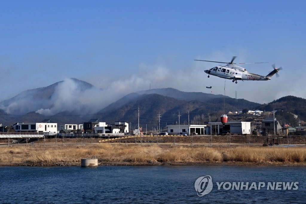 2月17日，在庆尚北道盈德郡盈德邑的山区，直升机正在洒水灭火。 韩联社/盈德郡政府供图（图片严禁转载复制）