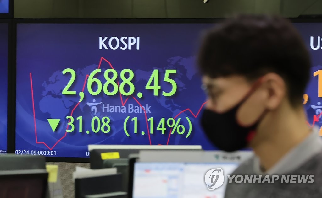 2月24日上午，在首尔市中区韩亚银行，交易员走过实时股价显示屏。 韩联社