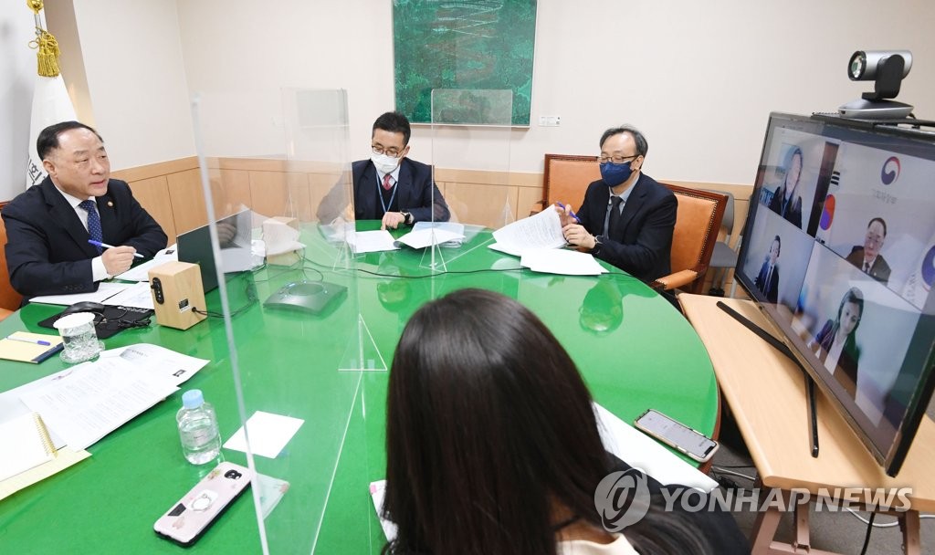 2月25日，在政府首尔办公楼，韩国企划财政部长官兼经济副总理洪楠基（左一）与国际信用评级机构穆迪公司举行视频会议。 韩联社