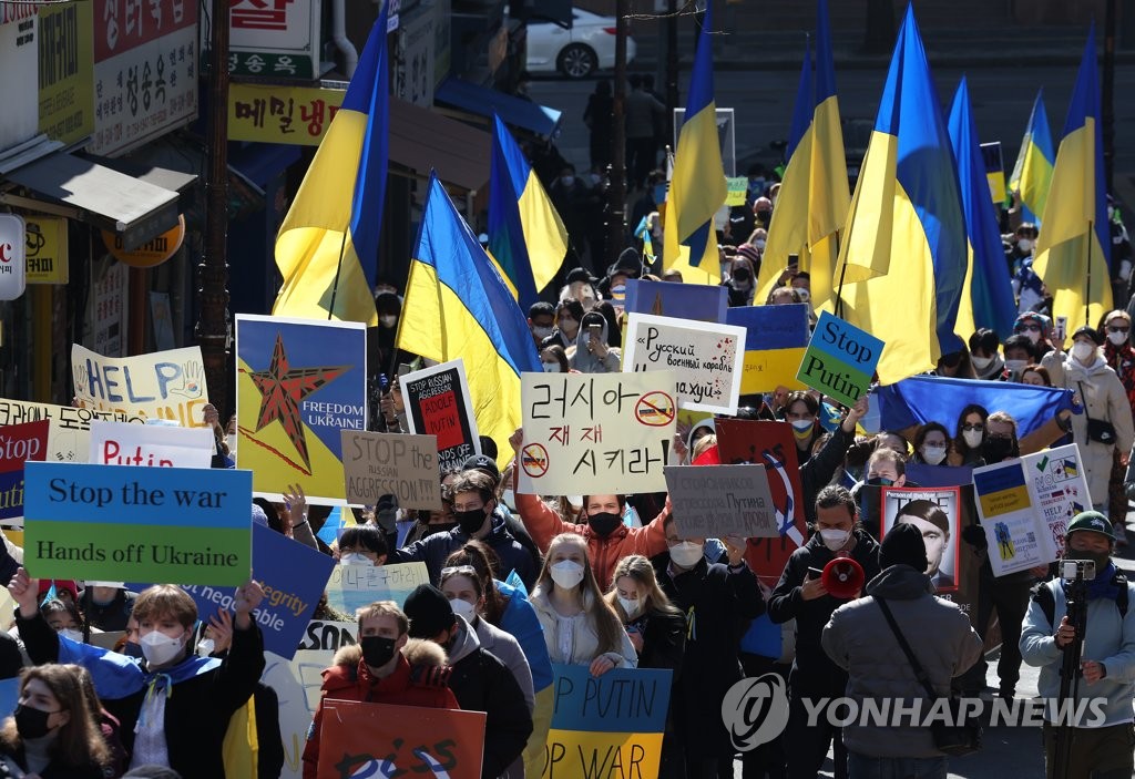资料图片：2月27日，在位于首尔中区的俄罗斯驻韩国大使馆附近，乌克兰人手举标语谴责俄罗斯进攻乌克兰。 韩联社