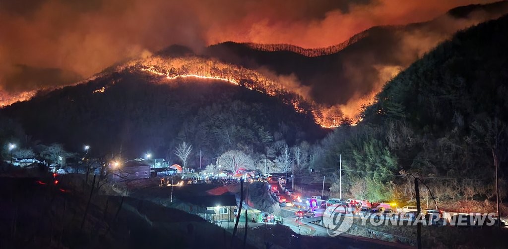 资料图片：2月28日，庆尚南道陕川郡发生森林火灾。图为火势猛烈的山火现场，摄于当天下午7时30分许。 韩联社/韩联社TV金完基（音）记者供图（图片严禁转载复制）