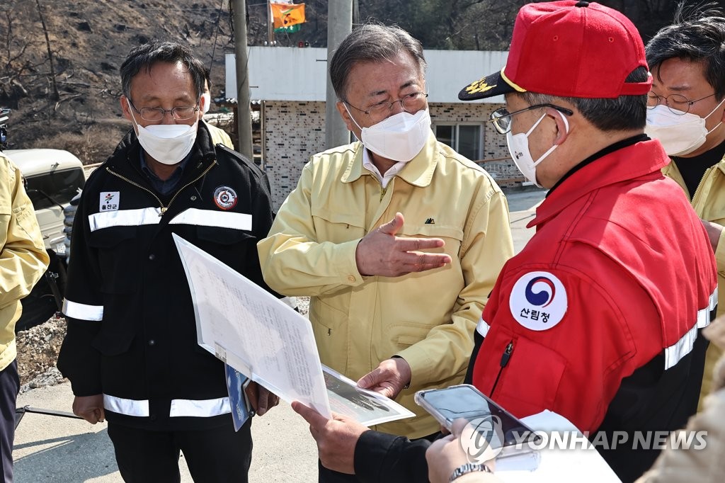 3月6日，在庆尚北道蔚珍郡新华2里，韩国总统文在寅（右三）听取山林厅厅长崔炳岩（右二）的东海岸火情报告。 韩联社