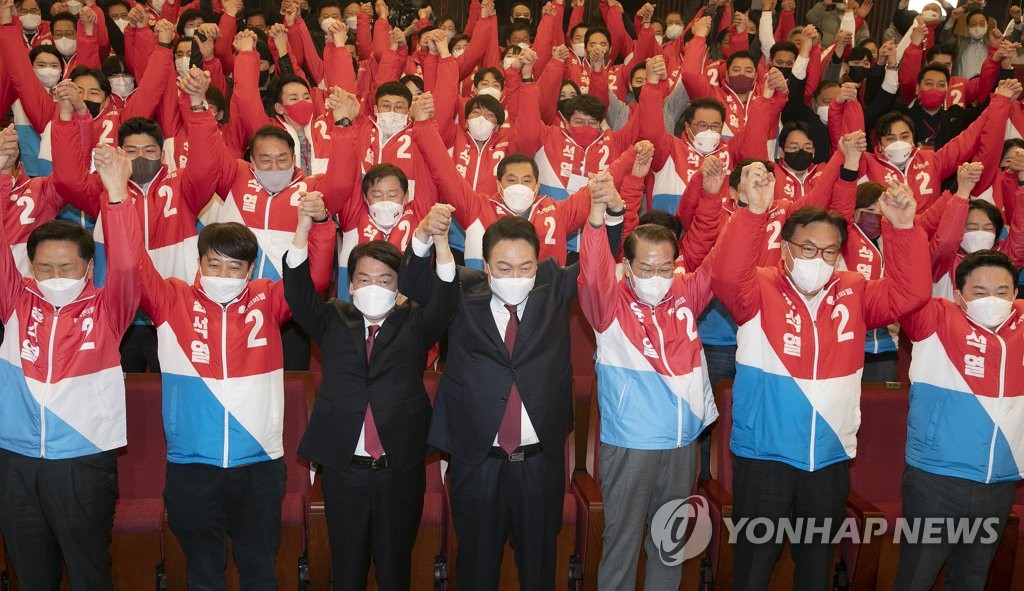 资料图片：3月10日，在设在首尔汝矣岛国会图书馆的国民力量开票状况室，尹锡悦（前排左四）和国民力量领导层欢庆胜利。 韩联社/国会摄影记者团
