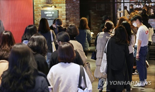3月12日晚，在首尔龙山区的星聚汇CGV龙山爱宝客购物城分店，防弹少年团的粉丝们正排队等待入场看演唱会直播。 韩联社
