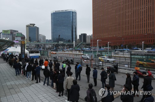 资料图片：3月14日，在设于首尔站广场的新冠临时筛查诊所，市民排长队等待接受病毒检测。 韩联社