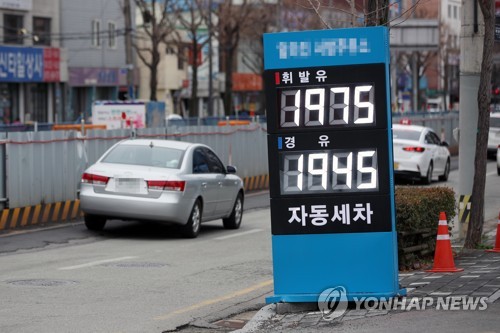 资料图片：这是光州市北区一家加油站的价格表，图片摄于3月18日。 韩联社