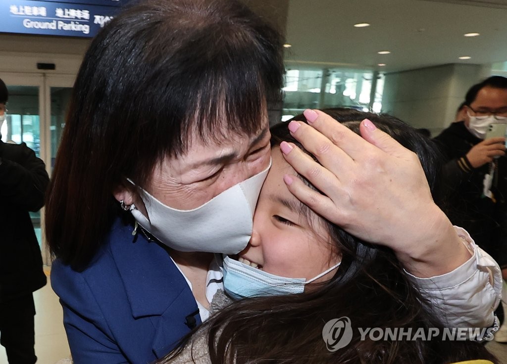 资料图片：3月22日，在仁川国际机场，一名从乌克兰撤离的高丽人小朋友（右）与亲人团聚。 韩联社