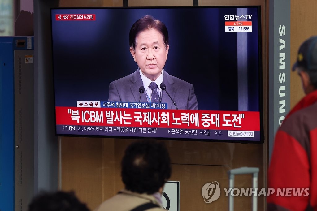 资料图片：3月24日，在首尔火车站的候车室，市民们正在收看朝鲜发射导弹的新闻。 韩联社