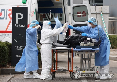 资料图片：医护人员移送患者就医。 韩联社