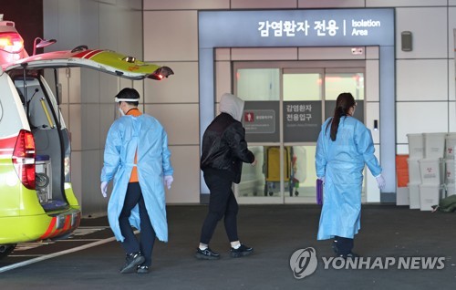 资料图片：医务人员移送新冠患者。 韩联社