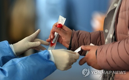 资料图片：3月28日，在首尔站的新冠筛查诊所，医务人员正准备进行病毒检测。 韩联社