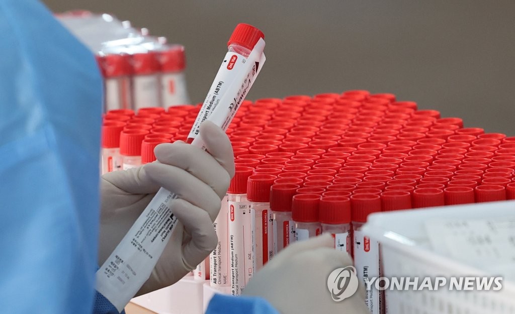 资料图片：医务人员准备进行新冠病毒检测。 韩联社