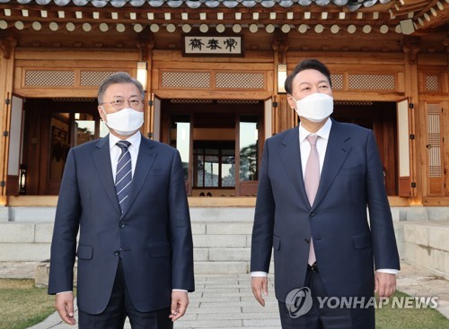 3月28日，在青瓦台，韩国总统文在寅（左）和候任总统尹锡悦在共进晚餐前交谈。 韩联社