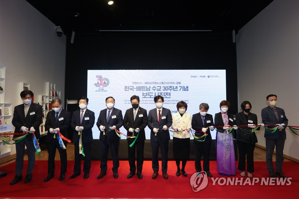 3月31日，纪念韩国和越南建交30周年的新闻摄影展在首尔大韩民国历史博物馆开幕。图为参加开幕式的来宾合影留念。 韩联社