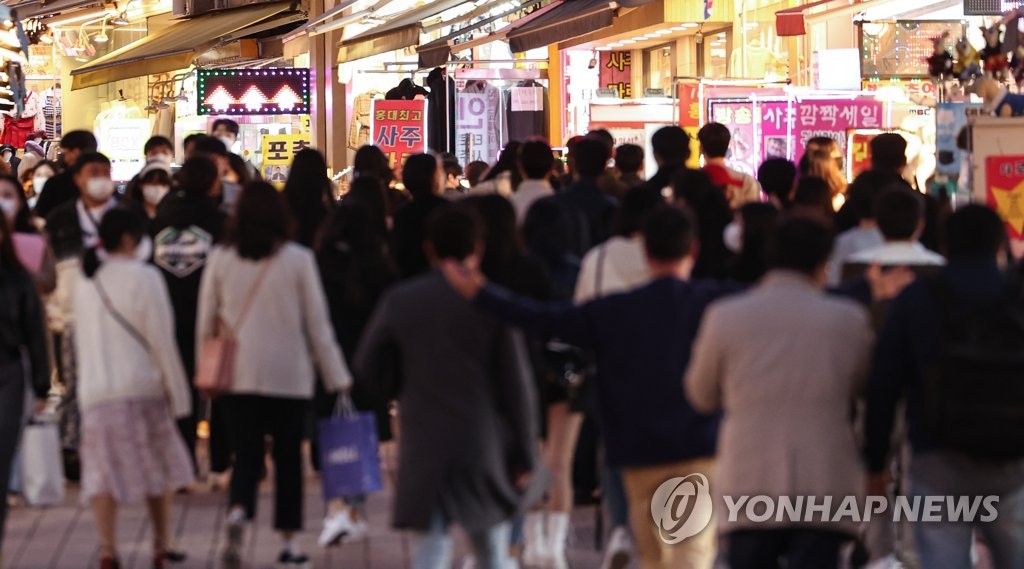 资料图片：3月31日，首尔麻浦区弘益大学前的一条商业街上人潮涌动。 韩联社
