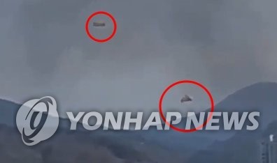 4月1日下午1时36分许，韩国空军两架KT-1教练机在庆尚南道泗川市正东面古邑里田野相撞坠毁。图为教练机相撞后，飞行员使用降落伞逃生。 韩联社/读者供图（图片严禁转载复制）
