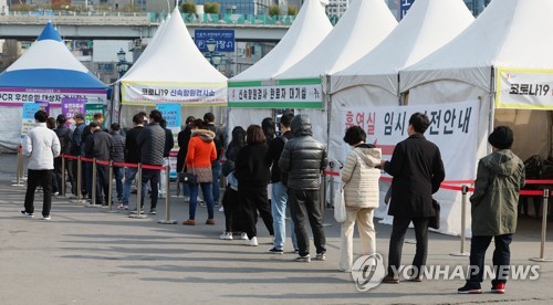 资料图片：4月5日，在设于首尔站的新冠临时筛查诊所，市民排队待检。 韩联社