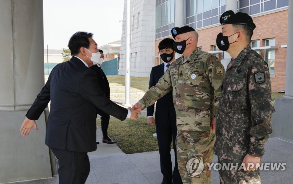 4月7日，在驻韩美军平泽基地“汉弗莱营”，韩国候任总统尹锡悦（左一）与驻韩美军司令兼韩美联合司令部司令保罗·拉卡梅拉（右二）握手致意。 韩联社/驻韩美军公报室供图（图片严禁转载复制）