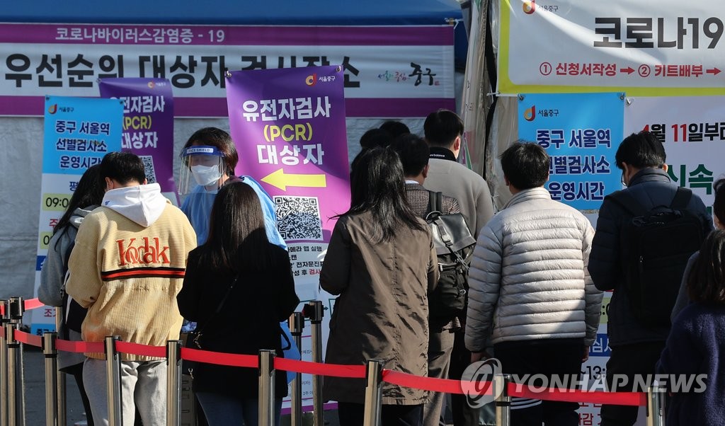 资料图片：在一处临时筛查诊所，市民排队待检。 韩联社