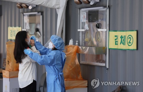 资料图片：4月11日，位于首尔广场的临时筛查诊所，市民接受新冠病毒检测。 韩联社