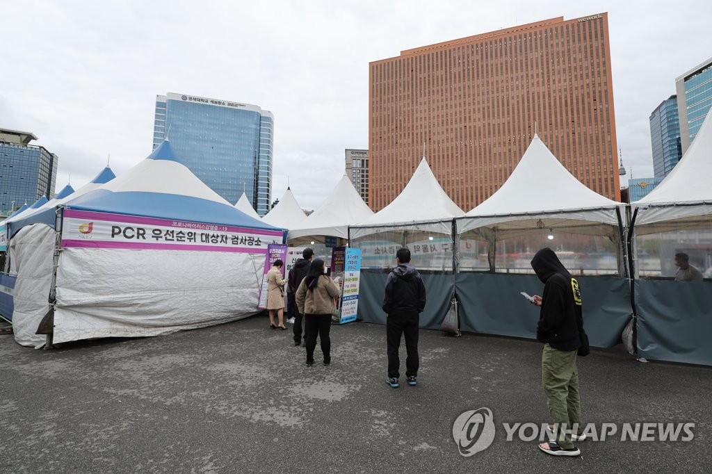 资料图片：4月13日，在设于首尔站的筛查诊所，市民等待接受病毒检测。 韩联社