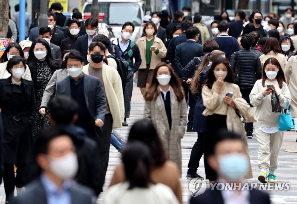 资料图片：市民佩戴口罩出行。 韩联社