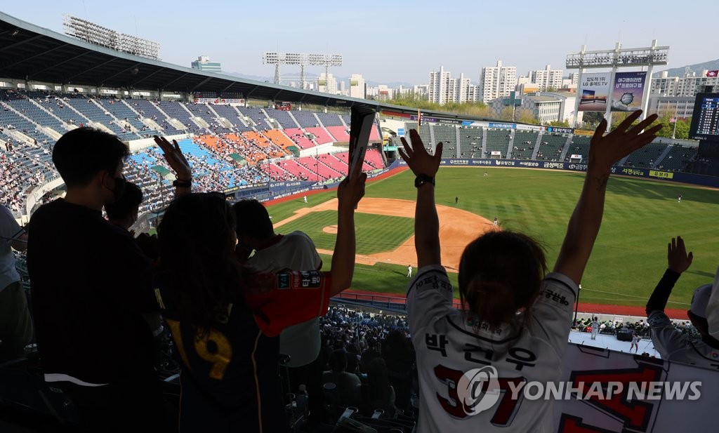 资料图片：4月17日，在首尔松坡区的蚕室棒球场，球迷们现场观战2022赛季韩国职业棒球联赛斗山熊队对阵培证英雄队的比赛。 韩联社