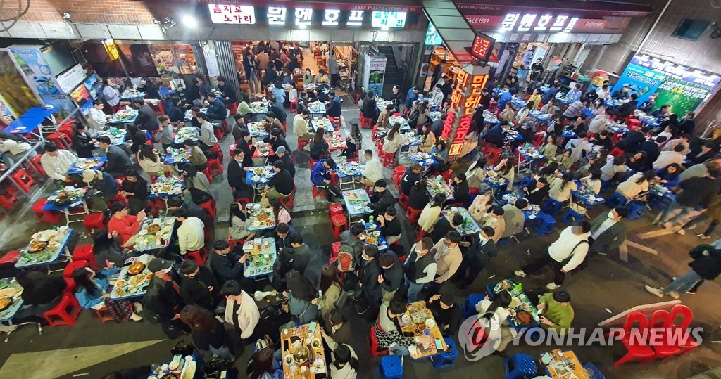 资料图片：4月18日晚，首尔市乙支路的一条小吃街再现往日的热闹景象。 韩联社