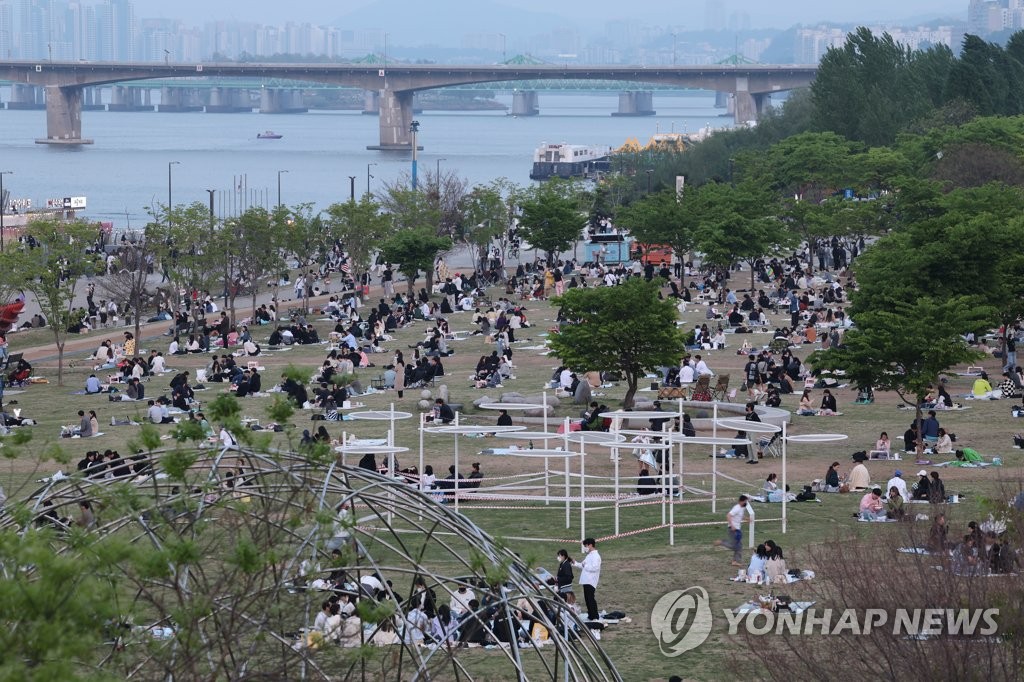 4月24日，首尔汝矣岛的汉江公园挤满了前来踏青春游的人群。当天是韩国解除保持社交距离措施后的首个周日。 韩联社