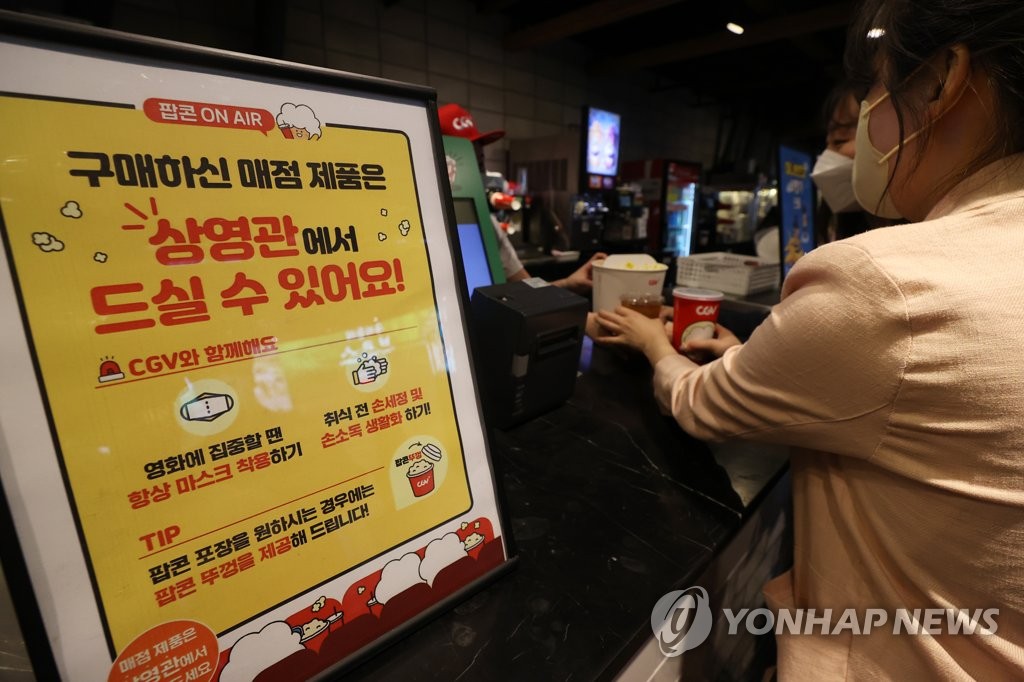 资料图片：4月25日，在首尔市星聚汇（CGV）影城龙山店，观众正在购买观影标配爆米花。因防疫一度实施的影院内禁食令当天被解除。 韩联社